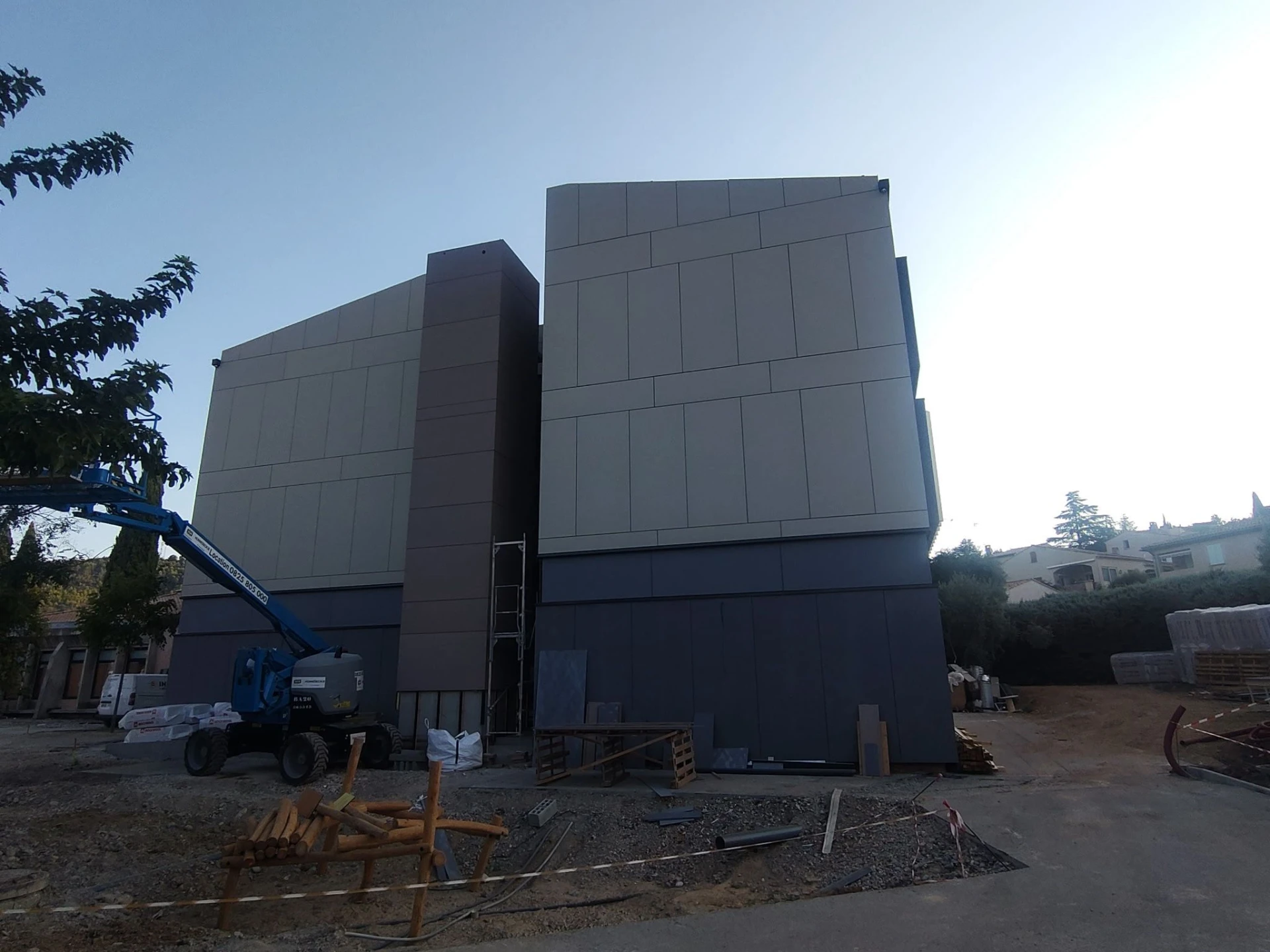 Pignon du groupe scolaire Le Colombier habillé en panneaux stratifiés, nacelle en place
