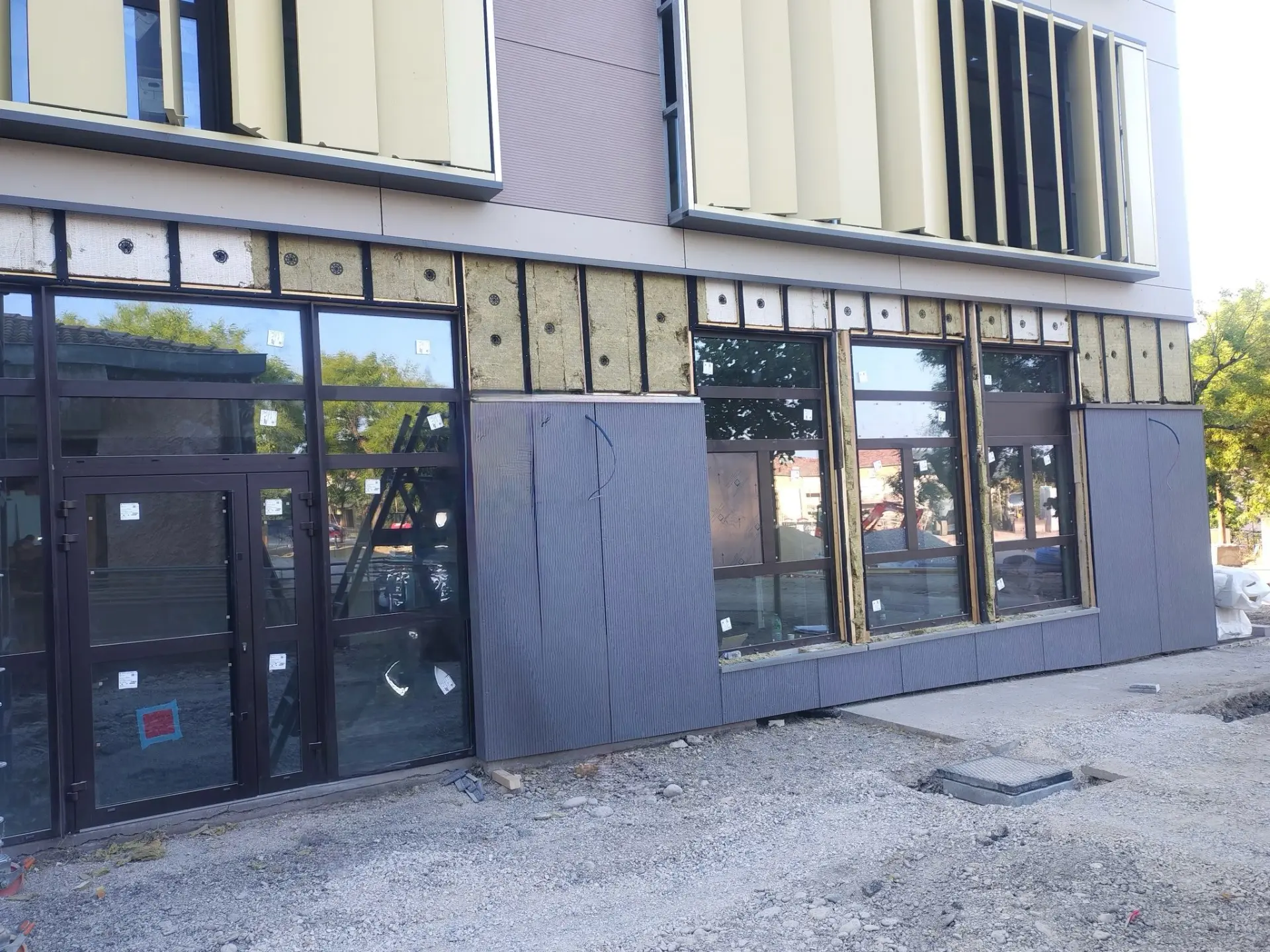 Ossature bardage et isolation laine de roche visibles en partie basse de la façade du groupe scolaire