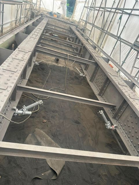 Structure métallique rivetée du pont de l'usine de Baratier après sablage, sous confinement intégral