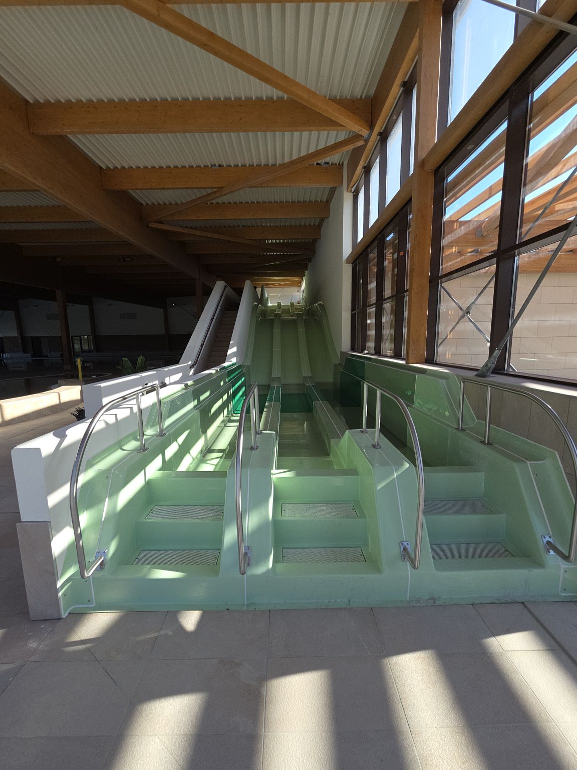 Accès aux bassins le long de la façade vitrée du centre aquatique Olivier Pleindoux