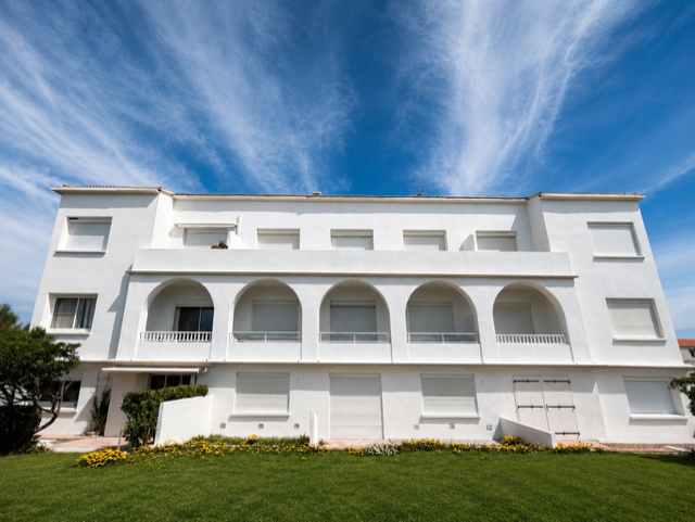 Façade blanche ravalée en I3 taloché inversé de la copropriété Le Grand Large aux Saintes-Maries-de-la-Mer